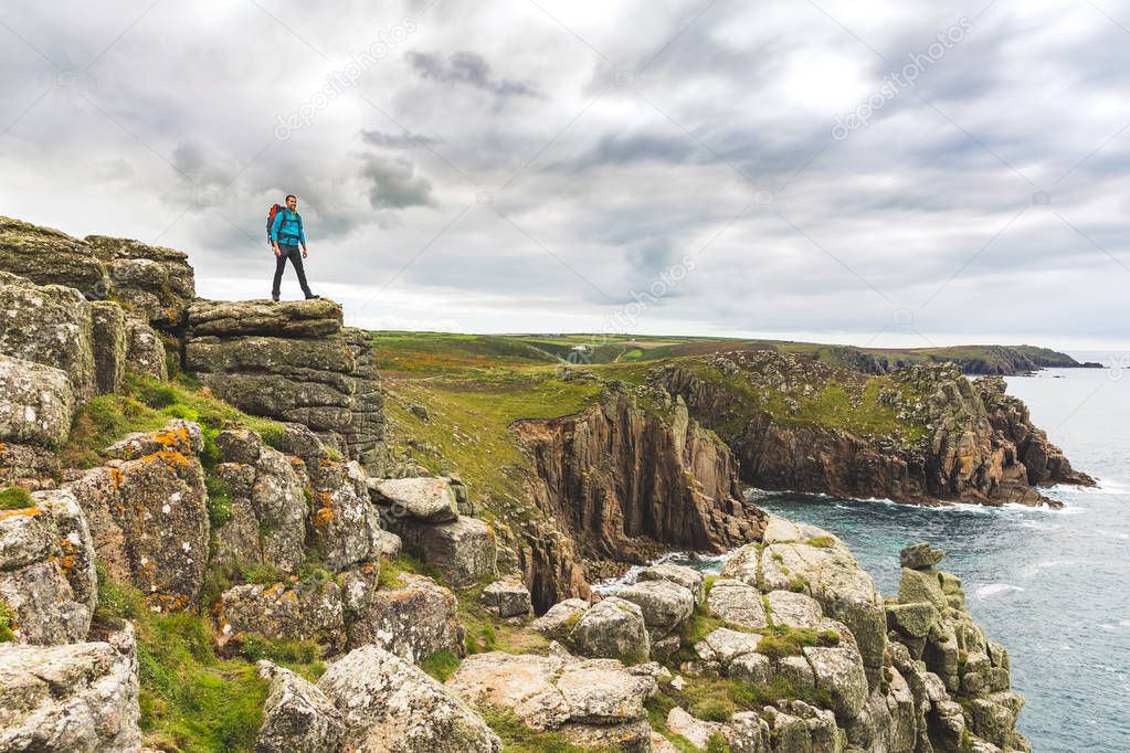 Man standing on a rock cliff enjoying the view