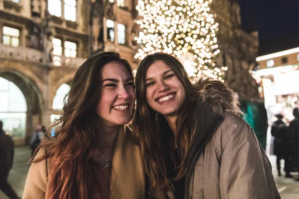 Teenager-Mädchen und Freunde lächeln mit Weihnachtsbaum auf Backgro — Stockfoto