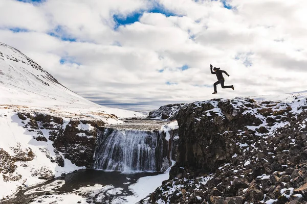 Grappige mens springen naast waterval in IJsland — Stockfoto