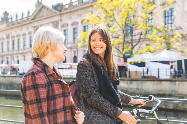 Deux femmes avec un vélo marchant à Berlin — Photo