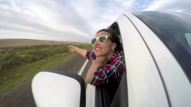 Beautiful woman out of car window enjoying the trip — Stock Video