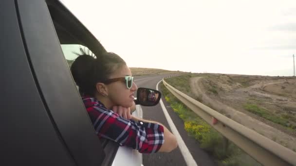 Beautiful woman out of car window enjoying the trip — Stock Video