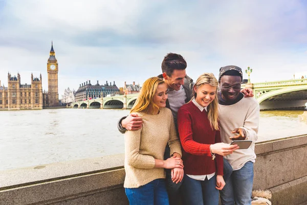 Vänner att ha kul med smartphone på Big Ben i London — Stockfoto
