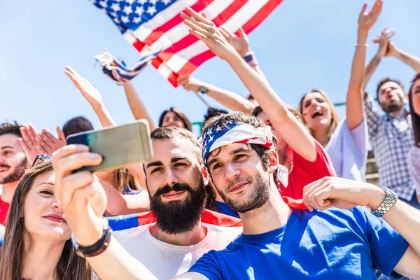 Aficionados estadounidenses tomando una selfie en el estadio durante un partido — Foto de Stock