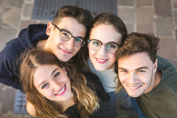 Portret van de tiener vrienden samen zitten op een muur in de stad — Stockfoto