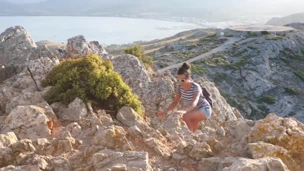 Όμορφη γυναίκα πάνω από βράχους σε Μαγιόρκα στο ηλιοβασίλεμα — Αρχείο Βίντεο