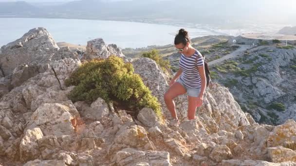 Mooie vrouw bovenop de rotsen in Mallorca bij zonsondergang — Stockvideo