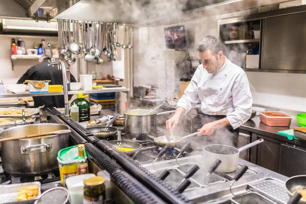 Cuoco che cucina in una cucina ristorante, vista attraverso il vapore — Foto Stock