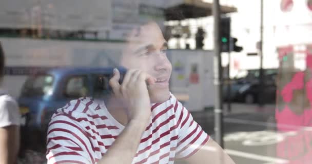 Mannen på caféet pratar i mobiltelefon — Stockvideo