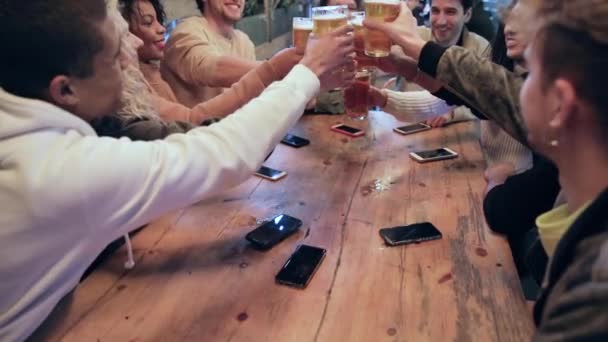 Grupo de amigos disfrutando de una cerveza en un pub de Londres, brindando y riendo — Vídeo de stock