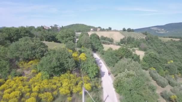 Чоловік їде на велосипеді з гірським велосипедом на сільській дорозі — стокове відео