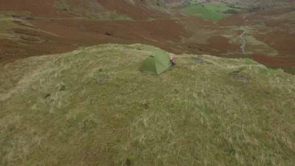 Wandelaar antenne uitzicht wandelen in de heuvels en slapen in een tent — Stockvideo
