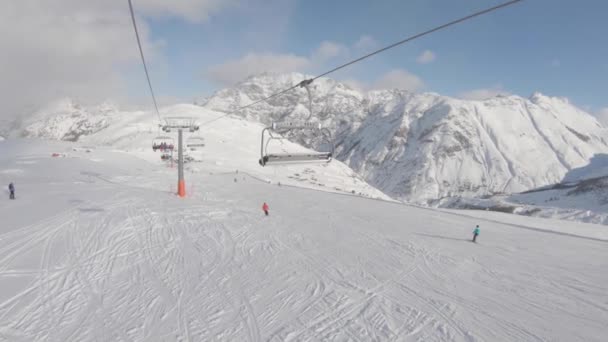 Skifahren auf schneebedeckter Piste im Skigebiet in den Bergen — Stockvideo