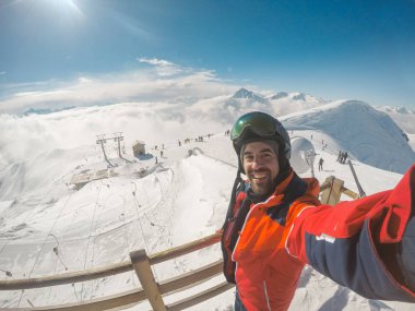 Kayak pistlerinin tepesinde selfie çeken bir adam.