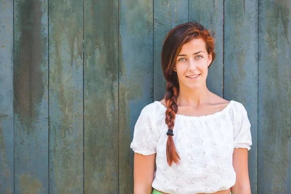 Chica sonriente con retrato de trenza sobre fondo de madera verde —  Fotos de Stock