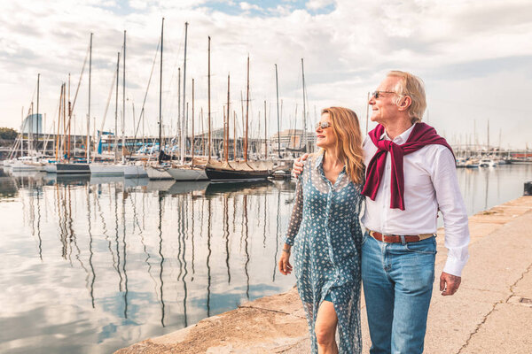 Senior couple walking near the port in Barcelona