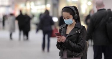 Londra tren istasyonundaki Çinli kadın sisli ve virüsten korunmak için maske takıyor - kalabalık bir yerde genç Asyalı kadın portresi virüs salgınından korunuyor - sağlık ve yaşam tarzı
