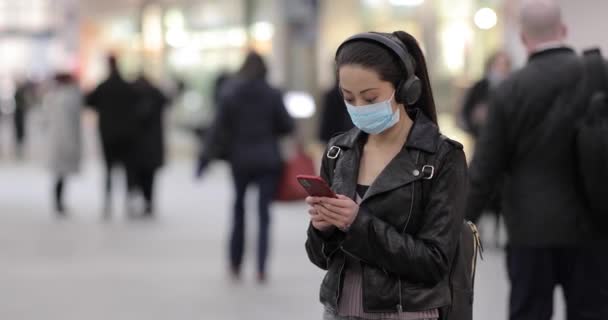 ロンドンの電車の駅で中国の女性は 顔のマスクを着て スモッグやウイルスから守るために 若いアジアの女性の肖像画は ウイルスの流行から保護忙しい公共の場所で 健康とライフスタイル — ストック動画