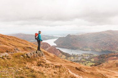 Photographer hiking and looking at panorama on top of mountain