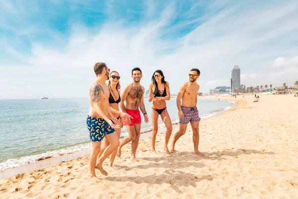 Gelukkige vrienden die plezier hebben op het strand in Barcelona — Stockfoto