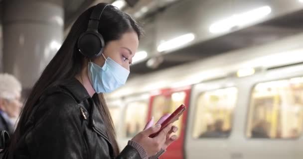 Chińska kobieta na dworcu kolejowym w Londynie w masce — Wideo stockowe
