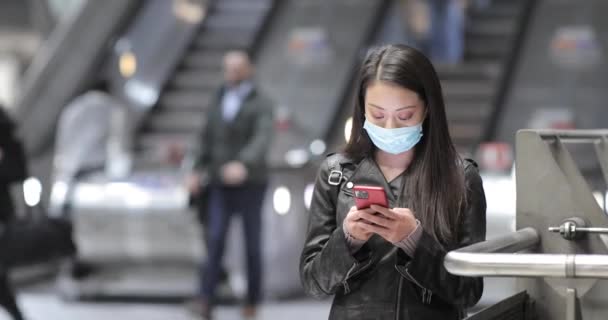 Κινέζα στο σταθμό του τρένου στο Λονδίνο φορώντας μάσκα προσώπου — Αρχείο Βίντεο