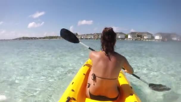 Maldivler sahil beldesinde kano süren bir kadın. — Stok video