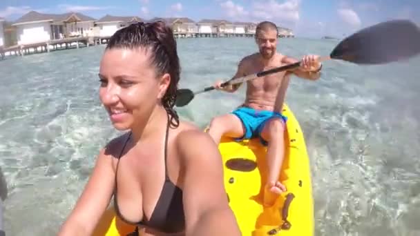 Pareja en un kayak en Maldivas balneario — Vídeo de stock