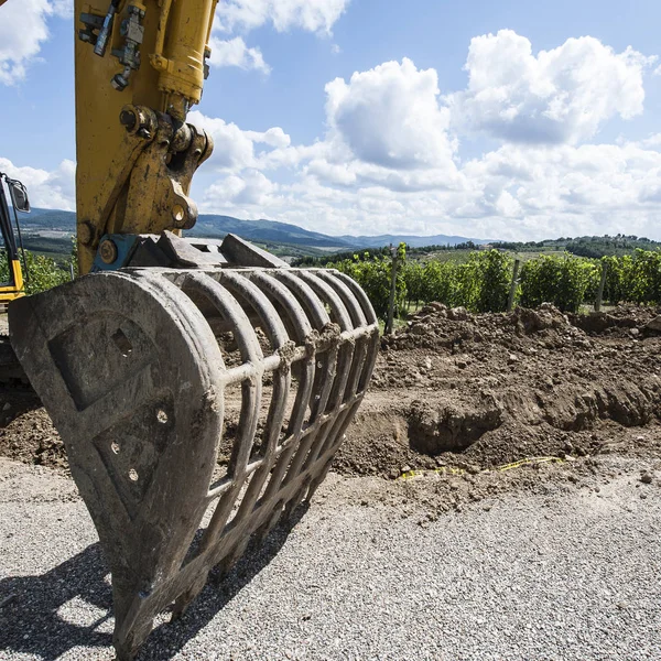 Excavator bucket near the vineyard — Stock Photo, Image
