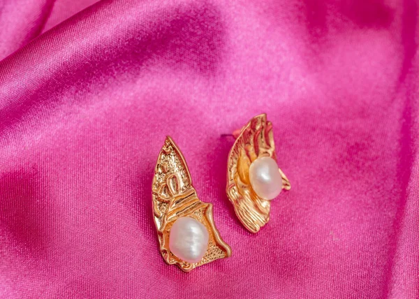Modern Asymmetrical Golden Earrings Pearl Beads Pink Silk Background — Stock Photo, Image