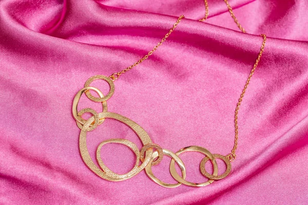 Mooie Glanzende Gouden Asymmetrische Ketting Met Verschillende Cirkelvormen Roze Achtergrond — Stockfoto