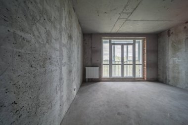 Konut yenileme şantiyesi. Yeni beton döşemeden önce boş oda
