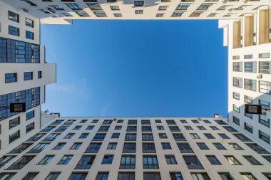 Modern, parlak binalar. İç mekan gökyüzüne bakıyor.