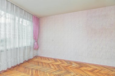 Boş bej renkli dairede perdeleri olan açık bir pencere güneşli bir sabah