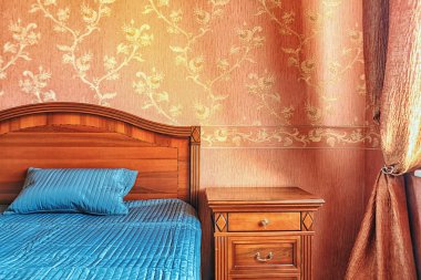 Sıcak tonlarda, rahat yatak odasında. Yatak ve gece yatağını kapat.