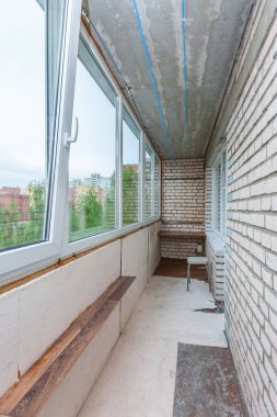 Küçük, eski, açık balkon. Yüksek apartmanlı, beton bina hizmetçisi.