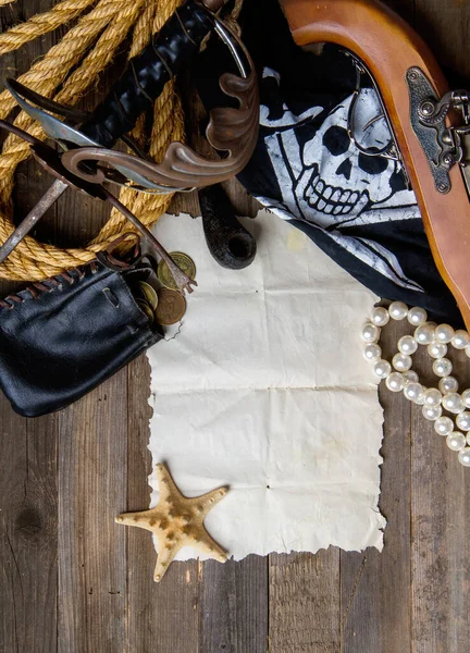 vintage pirate sword and pistol flag jolly roger and other medieval equipment lie on an empty paper scroll