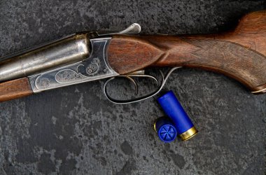 Eski klasik çift namlulu av tüfeği. 12 kalibrelik ve yakın plan karanlık bir arka planda.