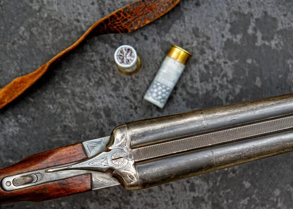 12口径の古典的な二重弾道狩猟ライフルとそれのためのカートリッジ暗い背景にクローズアップ — ストック写真