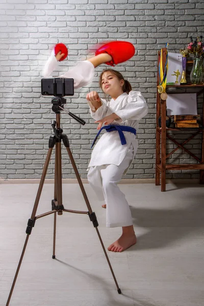 Маленькая Девочка Кимоно Занимается Онлайн Тренировкой Карате Мобильном Устройстве Воображаемым — стоковое фото