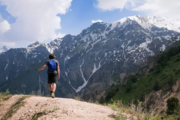 Jovem turista em montanhas com um poste de passeio — Fotografia de Stock