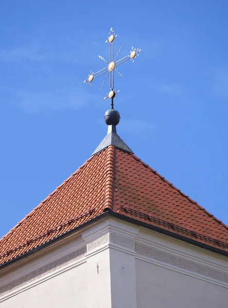 Cruz dorada sobre techo de teja roja — Foto de Stock