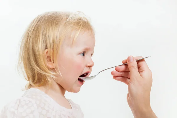 La niña es alimentada con cuchara — Foto de Stock