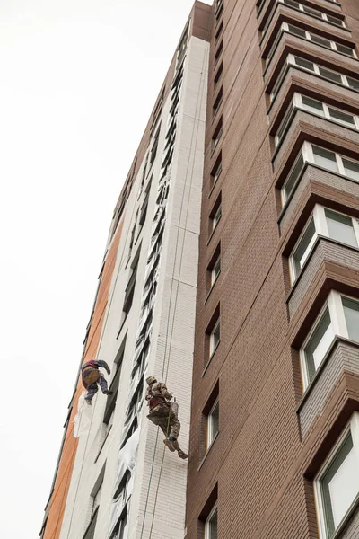 Escaladores industriales suben a una fachada del edificio — Foto de Stock