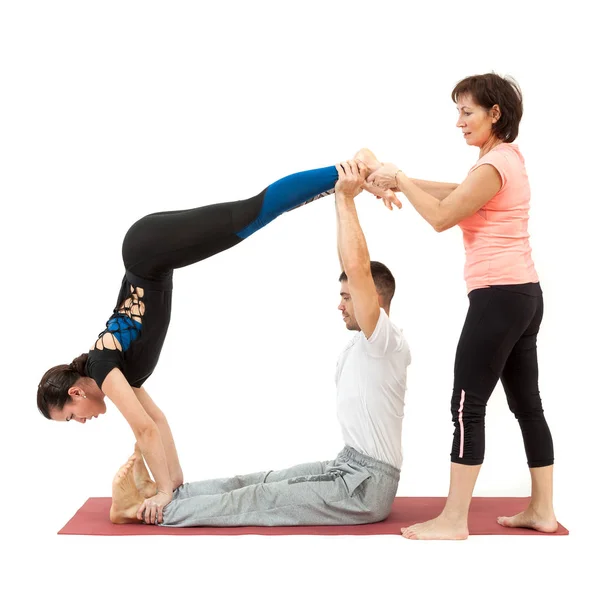 Hombre y mujer haciendo yoga bajo la guía de un entrenador —  Fotos de Stock