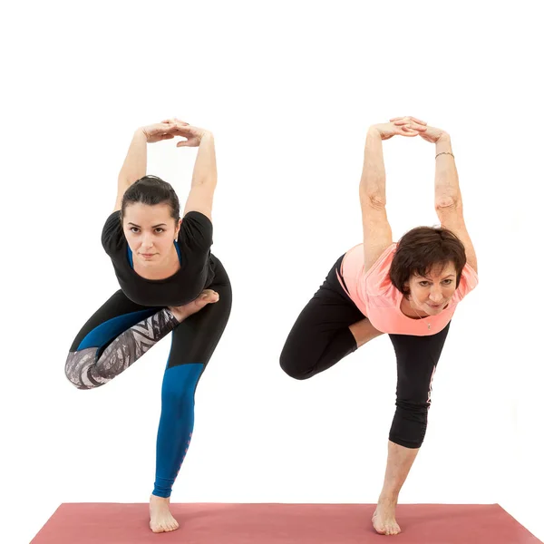 Jong meisje en rijpe vrouw doet yoga — Stockfoto