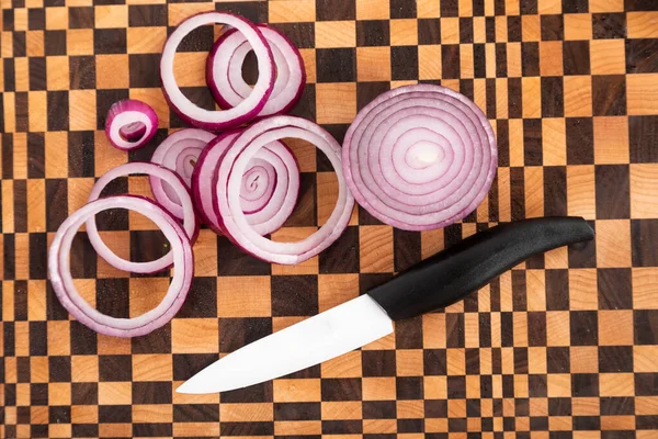 Cipolla rossa dolce tagliata ad anelli con un coltello . — Foto Stock