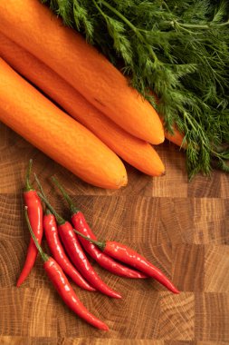Havuç ve biber, ahşap kesme tahtasındaki yeşiller.
