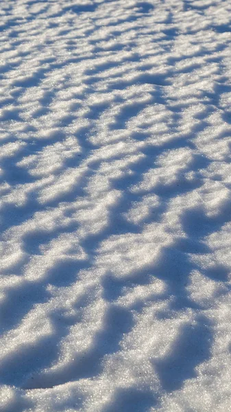 Textura de nieve. El fondo iluminado por nieve . —  Fotos de Stock