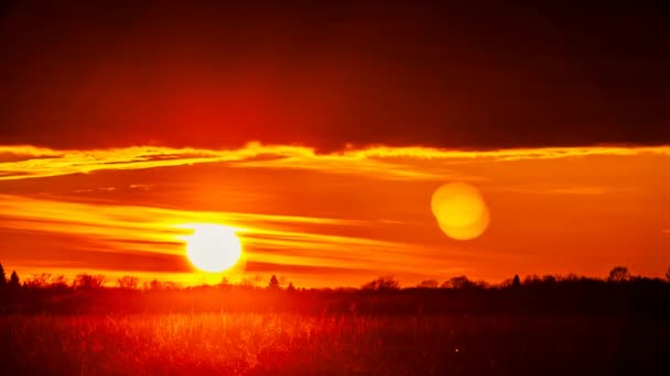 フィールドの上に明るい赤の夕日 ビデオ時間の経過 — ストック動画